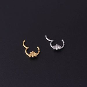 Golden and silver bee-shaped stainless steel piercing rings on a dark background