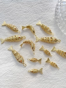 Makroaufnahme von 10 goldenen Koi-Anhängern mit orangefarbenen Akzenten auf Stoff