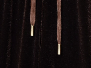 Detailed macro view of brown velvet fabric with woven drawstring and gold metal tips