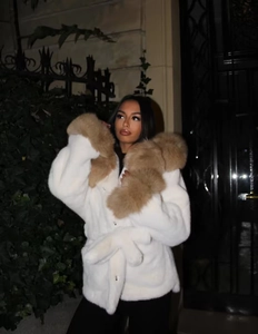 Gros plan sur le manteau en fausse fourrure blanche avec col et poignets en fourrure