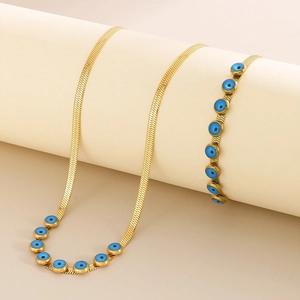 Detailed shot of golden snake chain with blue evil eye beads on a jewelry display