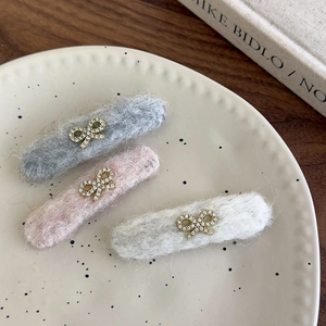Three plush hair clips in grey, pink, and white with sparkling rhinestone bows decoration