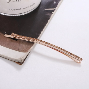 Detail of rose gold hair clip with champagne crystals on a magazine background