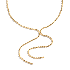 Détail macro d'un collier lariat doré avec des billes en métal sur fond blanc épuré
