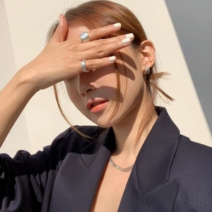 Close-up of minimalist double-layer 925 silver rings and earrings with dramatic lighting