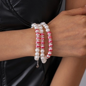 Détail du bracelet à trois rangs avec des perles d'imitation marbrées blanches et rouges