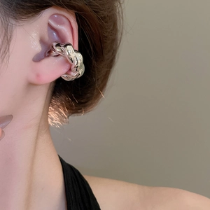 Vue détaillée du clip d'oreille torsadé argenté porté sur le cartilage du mannequin