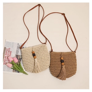 Detail of straw bags with wooden beads, tassels and slim brown leather shoulder straps