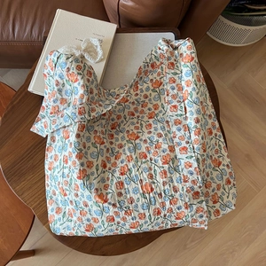 Detail of floral print fabric with subtle pleated texture and a delicate lace bow accent