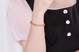Close-up of gold infinity link bracelet worn on wrist showing detailed metal texture
