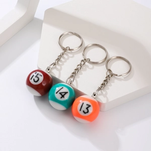 Close-up of resin billiard ball keychains in red, green, and orange with numbers