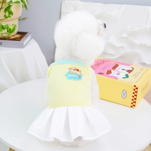 Detail of pet dress featuring yellow knit top and white pleated skirt with puppy embroidery