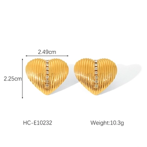 Macro shot of 18k gold textured heart earrings with vertical rhinestones on white background
