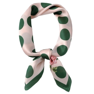 Pink silk scarf with green polka dots and rose patterns shown in a stylish knot