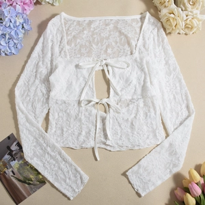 Detail of white lace long-sleeve crop top featuring elegant double bow tie-up front closure