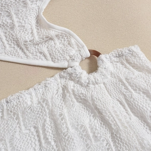 Detail of white crochet knit beach dress with brown resin ring connector