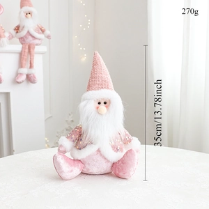 Detail shot of a sitting pink Santa plush doll with sequin fabric on a white surface
