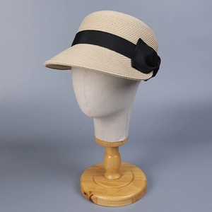 Cappello da sole elegante in paglia beige con fiocco nero su espositore
