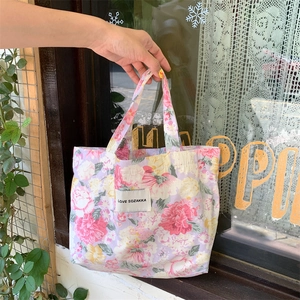 Détail du sac cabas floral en toile avec fleurs roses et étiquette Love Sozakka en extérieur
