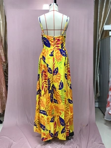 Back view of a yellow bohemian maxi dress with tropical leaf patterns on a mannequin