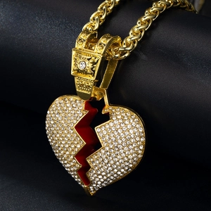 Close-up of hip hop gold broken heart pendant necklace with red accents and crystals