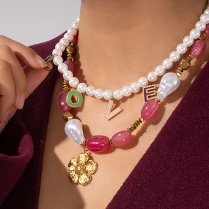Boho layered necklace with pearls, pink stones, and a golden flower pendant