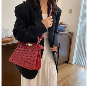 Detailed shot of red woven texture handbag featuring premium gold metal hardware clasp