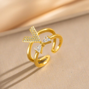 Detailed close-up of gold V-shaped ring with pavé zircons and bow design on silk