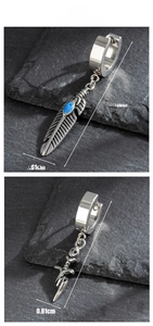 Macro shot of punk style steel earrings with turquoise feather and skull sword charms