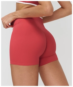 Gros plan du short de yoga rouge avec bandes latérales blanches montrant la coupe