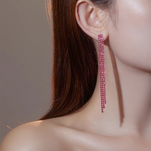 Elegante lange Quasten-Ohrringe mit funkelnden rosa Strasssteinen an einem weiblichen Model