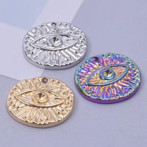 Three stainless steel evil eye pendant charms in gold, silver, and rainbow finishes