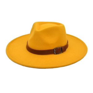Détail du chapeau en laine jaune à large bord avec bande en cuir brun et boucle métal