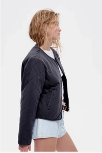 Detailed side view of women's dark grey quilted bomber jacket with diamond pattern texture