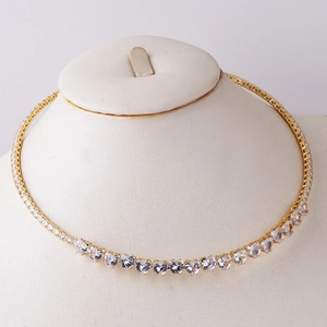 Detail of elegant gold necklace featuring crystal heart-shaped stones on neck model