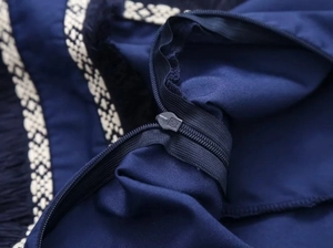 Vue détaillée de la fermeture éclair invisible et dentelle beige sur tissu bleu