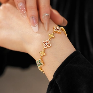 Primer plano de una pulsera vintage de oro con flores de circonita en la muñeca