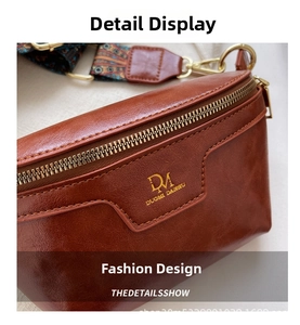 Detailed close-up of brown textured leather bag with gold logo and colorful strap