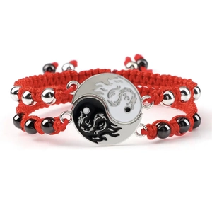 Detailed macro of red woven Tai Chi bracelets with Yin Yang dragon charms and beads