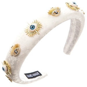 Detail of white sponge headband with embroidered evil eye patterns and crystal accents