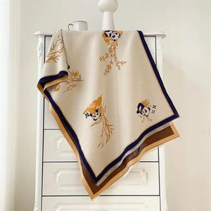 Detailed view of mulberry silk scarf with panda pattern hanging on a vintage dresser