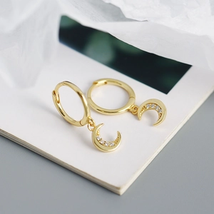 Macro shot of gold crescent moon hoop earrings with small clear zircon stones inlay