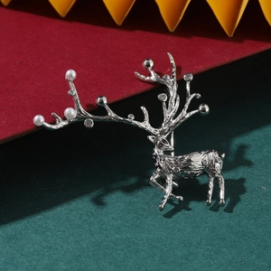 Broche renne argentée avec perles blanches et zircons sur fond festif de Noël