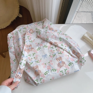 Detail of floral canvas tote bag featuring cute teddy bear and rose pattern print