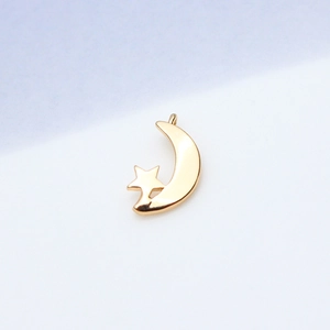 Macro shot of gold star and crescent moon pendant with micro-inlaid cubic zirconia