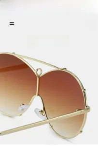 Detailed close-up of gold double-bridge sunglasses frame with soft silicone nose pads