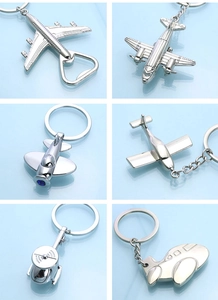 Detail of silver metal aircraft keychains showing various jet models and bottle openers