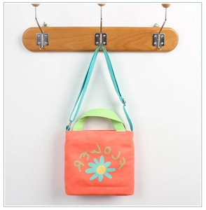 Close-up of orange canvas bag with blue adjustable strap and cute flower prints