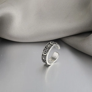 Macro view of vintage silver feather ring with embossed sun and moon celestial motifs