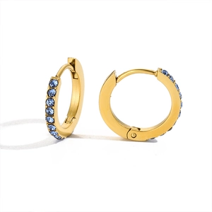 Close-up of golden stainless steel hoop earrings set with small blue rhinestones